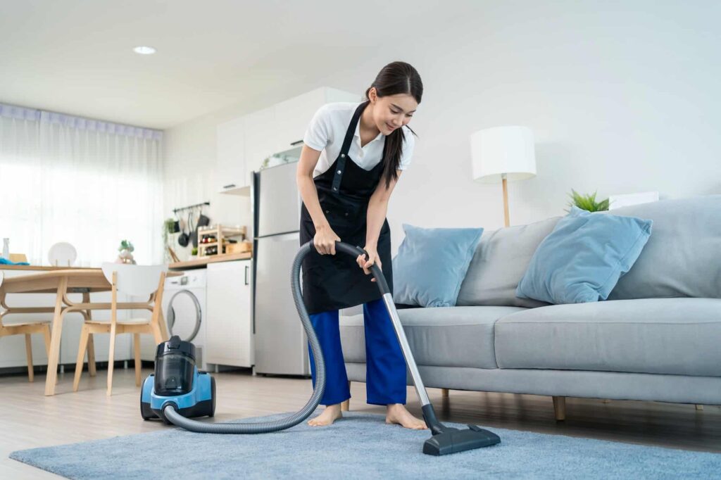 Asian cleaning service woman worker cleaning in the living room at home, embodying the professionalism and dedication of our cleaning services.