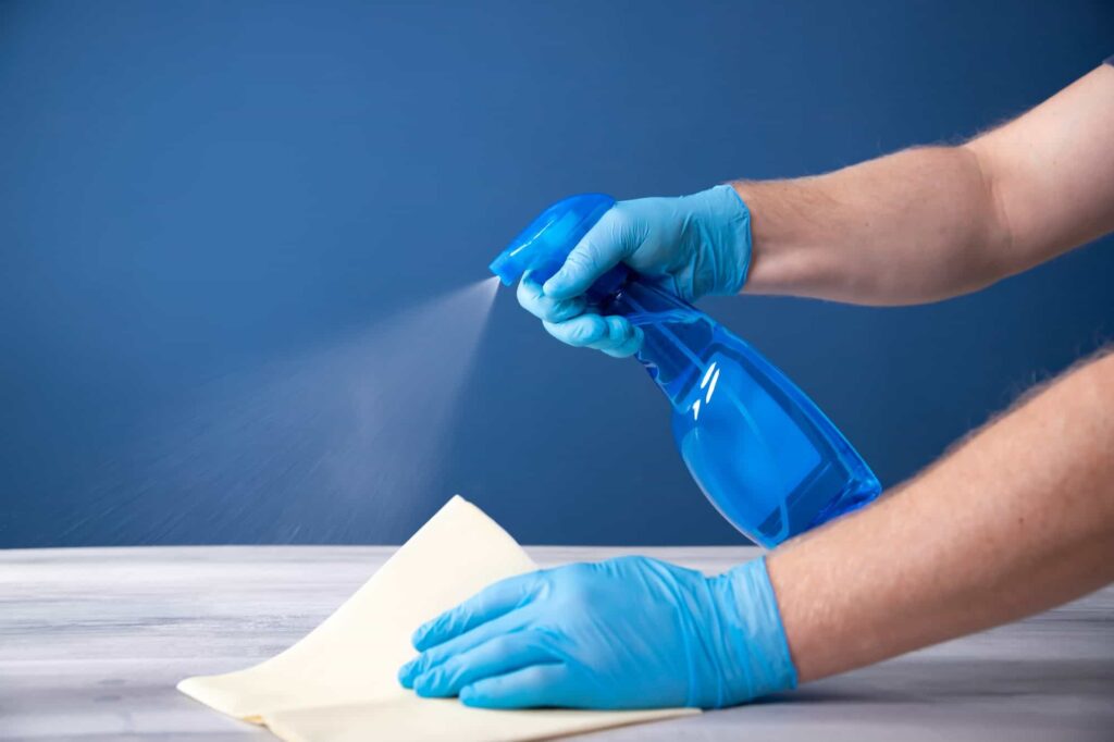 Thoroughly disinfecting surfaces with an antiseptic during a coronavirus epidemic, showcasing our commitment to hygiene and safety in our cleaning services in Sydney's best cleaning company.